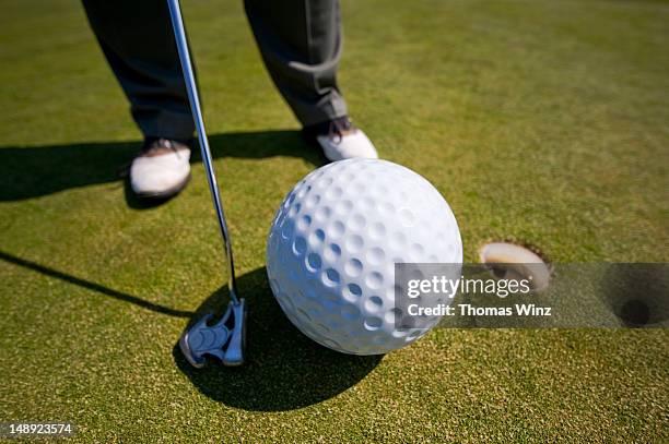 man playing golf with oversized ball. - big driver golf stock pictures, royalty-free photos & images