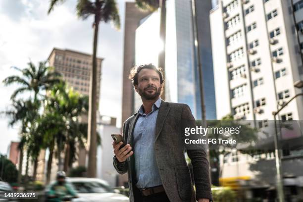 mature businessman walking in the street - avenida paulista imagens e fotografias de stock