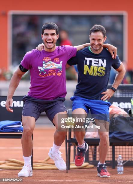 Carlos Alcaraz of Spain stretches with Juanjo Moreno during a training session on Day Four at Foro Italico on May 11, 2023 in Rome, Italy.