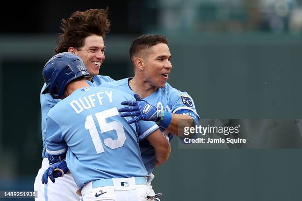 Matt Duffy and Nate Eaton of the Kansas City Royals celebrate with Freddy Fermin after Fermin's walk-off bunt scored the winning run during the...