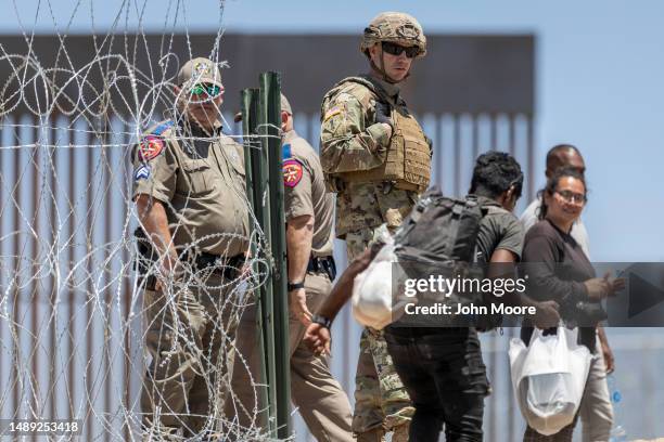 Texas National Guard soldier watches as a migrant walks into a makeshift migrant camp on May 11, 2023 in El Paso, Texas. The number of immigrants...