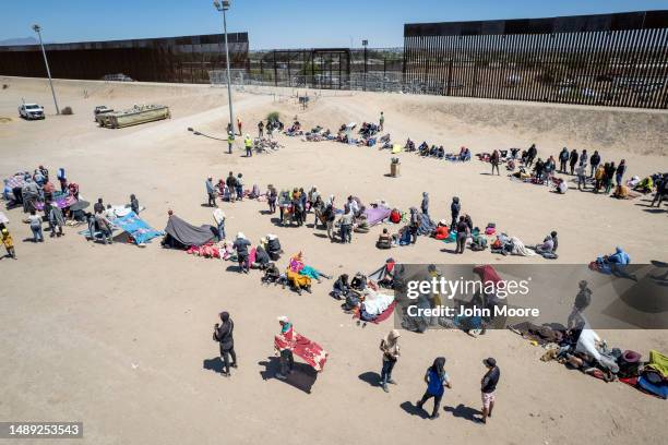 In an aerial view, immigrants gather at a makeshift migrant camp next to the U.S.-Mexico border fence on May 11, 2023 in El Paso, Texas. The number...