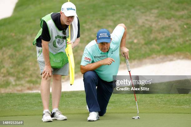 Padraig Harrington of Ireland lines up a putt with his caddie on the third green during the first round of the Regions Tradition at Greystone Golf...