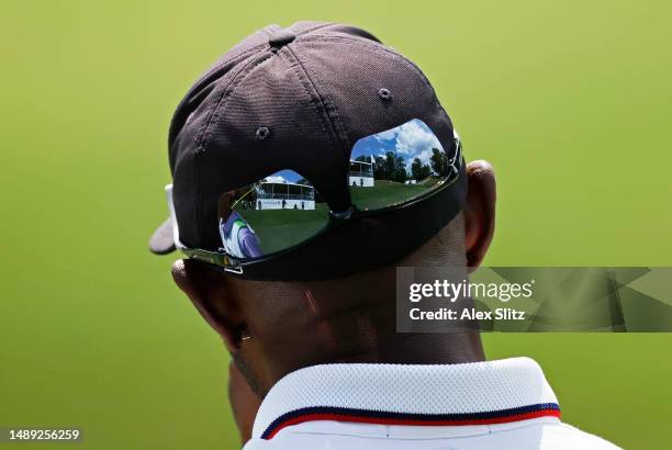 Seating around the ninth green is reflected in the sunglasses of Timothy O'Neal of the United States during the first round of the Regions Tradition...