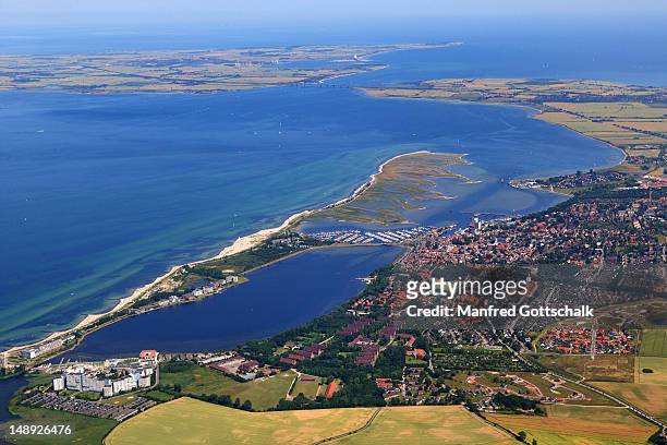 aerial view of town and baltic coast, with steinwarder/graswarder peninsula, binnensee and fehmarn island in background. - fehmarn - fotografias e filmes do acervo