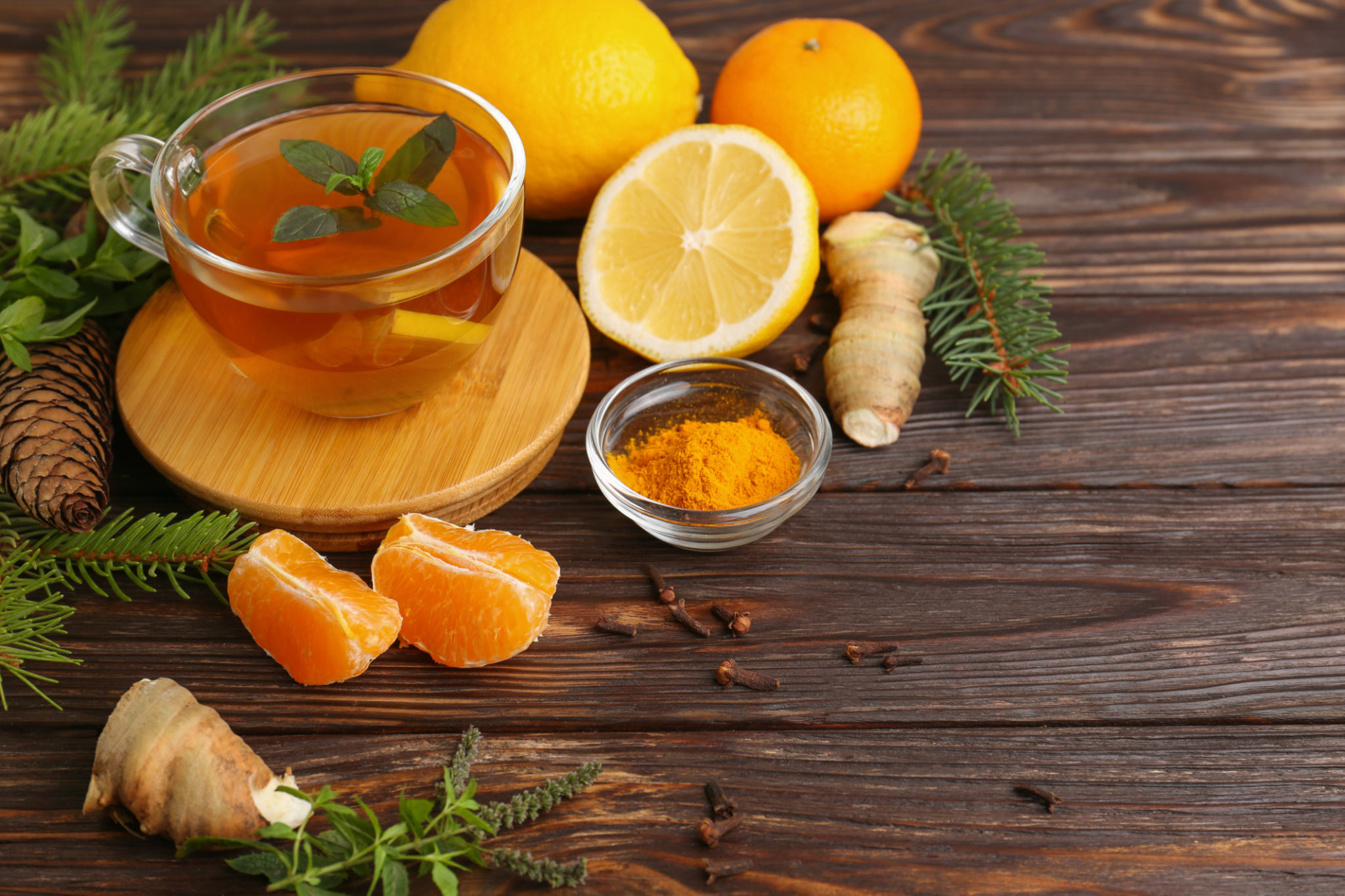 Glass cup of delicious immunity boosting tea and ingredients on wooden table. Glass cup of delicious immunity boosting tea and ingredients on wooden table.