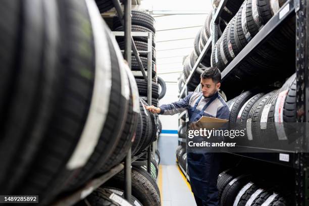 mann, der eine bestandsaufnahme macht, während er in einer reifenfabrik arbeitet - reifen stock-fotos und bilder