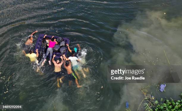An aerial view of migrants making their way across the Rio Grande to enter the United States on May 11, 2023 in Matamoros, Mexico. A surge of...