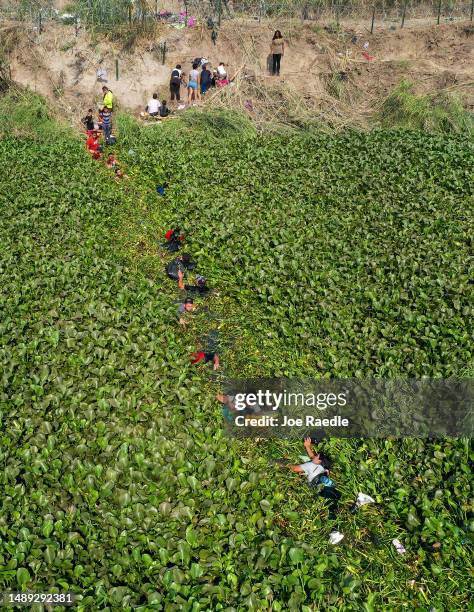 An aerial view of migrants making their way across a lily weed choked part of the Rio Grande to enter the United States on May 11, 2023 in Matamoros,...