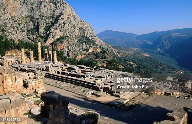 the temple of apollo has survived since the 4th century b.c. in a region notorious for earthquakes. situated on the slopes of mt pararnassos there are magnificent views down the olive tree strewn valley. - delfi foto e immagini stock