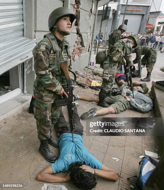 Chilean soldiers arrest and restrain alleged looters in downtown Concepcion, Chile, March 2, 2010. Thousands more troops were deployed across...