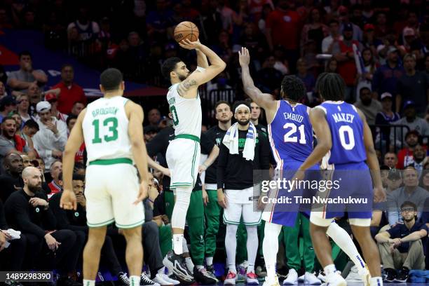 Jayson Tatum of the Boston Celtics shoots a three point basket against Joel Embiid of the Philadelphia 76ers during the fourth quarter in game six of...