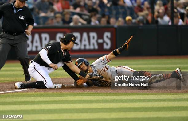 Thairo Estrada of the San Francisco Giants is tagged out by Josh Rojas of the Arizona Diamondbacks while attempting to steal third base during the...