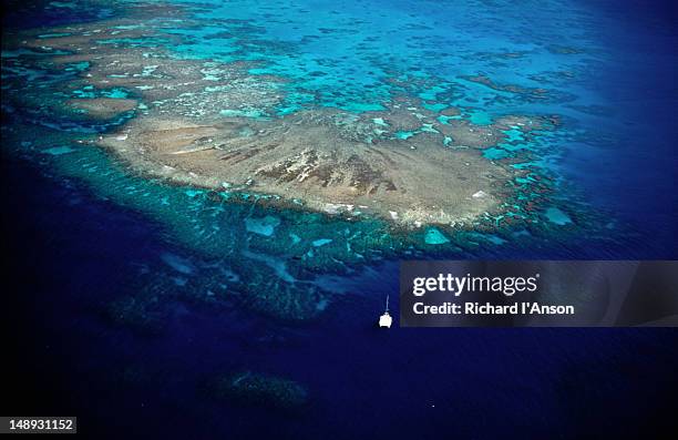 a dive boat moored off sandy cay. among the other outer reefs (double island, arlington reef), sandy cay is a popular destination for dive groups. - diving off boat australia stock-fotos und bilder