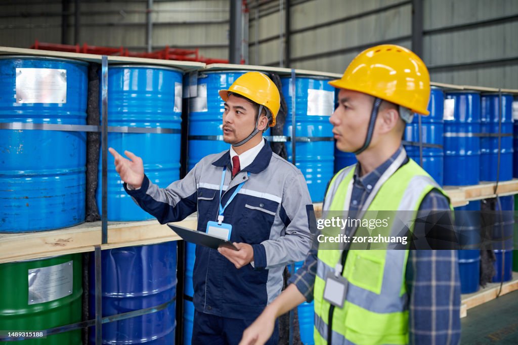 化学品倉庫で診察&議論する2人のアジア人男性