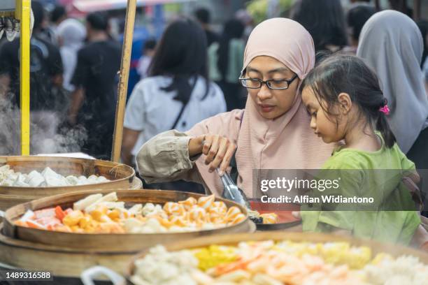 buying street food - abbigliamento religioso foto e immagini stock