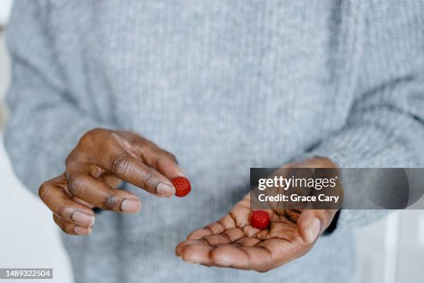 woman holds fruit-flavored gummies - gummy snoep stockfoto's en -beelden