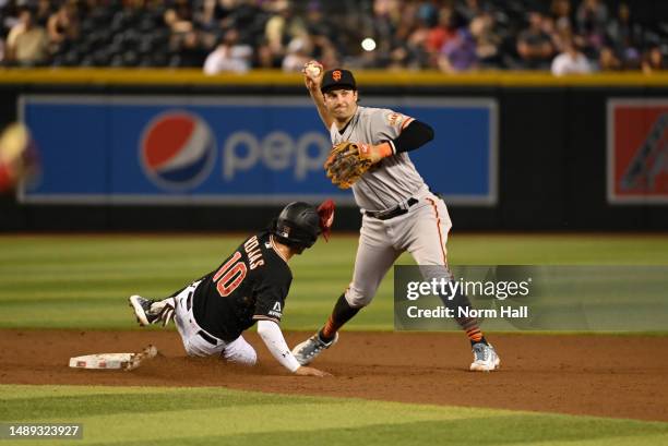 Casey Schmitt of the San Francisco Giants turns a double play on a ground ball hit by Ketel Marte of the Arizona Diamondbacks as Josh Rojas is forced...