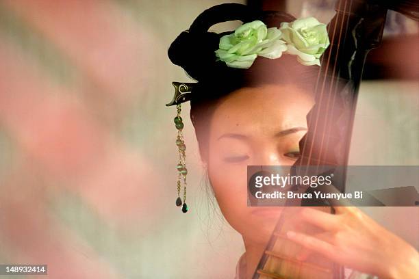 young female musician in traditional dress playing pipa, traditional plucked string instrument, inside hall of zhouzheng yuan (humble administrator's garden). - sopa images imagens e fotografias de stock