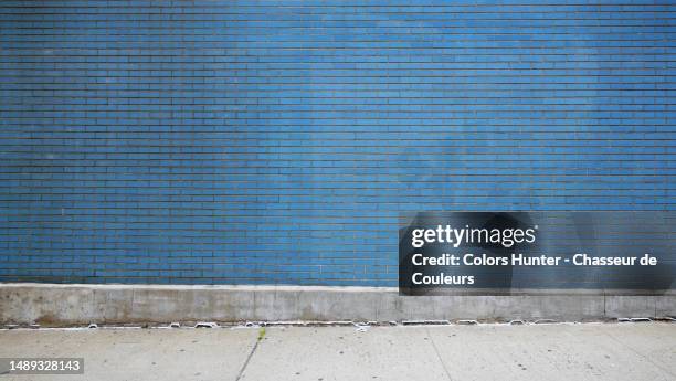 empty blue brick wall and cement sidewalk in manhattan, new york, united states - hunter, new york stock-fotos und bilder