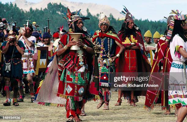 costumed performers taking part in the inti raymi procession, a spectacle staged at an incan ruins site for tourists. - inti raymi festival stock pictures, royalty-free photos & images