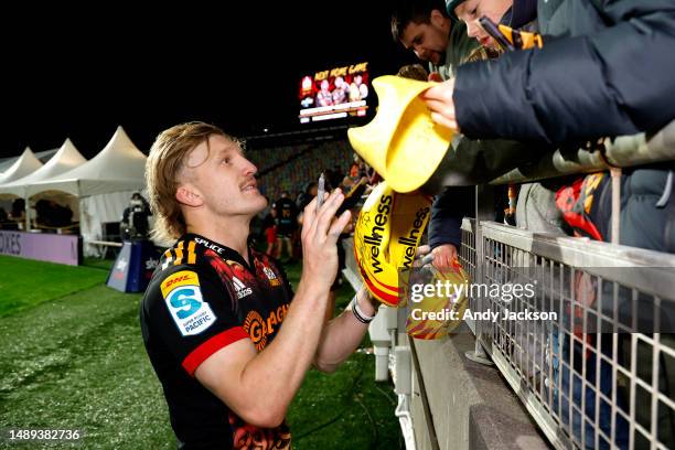 Damian McKenzie of the Chiefs signs autographs for fans after losing the round 12 Super Rugby Pacific match between Chiefs and Queensland Reds at...