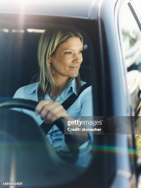 smiling businesswoman going on a trip by car. - business person driving stockfoto's en -beelden