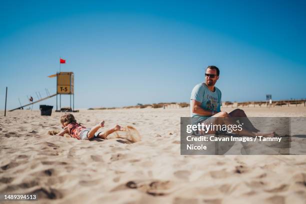 father and son playing in the sand at beach in canary islands - family sports centre laughing stock pictures, royalty-free photos & images