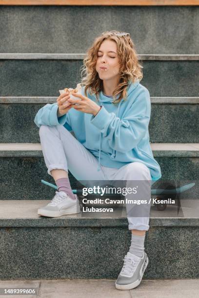 young woman chewing street food outdoors, lifestyle - lavash stock pictures, royalty-free photos & images