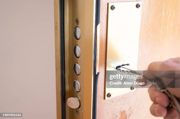 a person holds the keys and in front of a new and nice residential building. - fechadura imagens e fotografias de stock