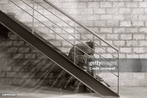 despair; man sitting with hands on head - racism concept stock pictures, royalty-free photos & images