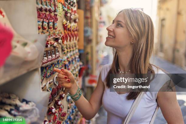 teenage girl browsing souvenirs at street stand - souvenir magnet stock pictures, royalty-free photos & images