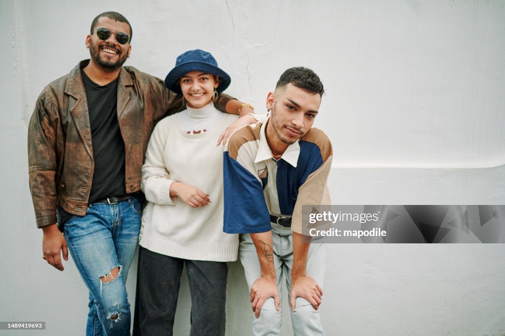 Portrait of a multiracial group of LGBTQIA friends smiling looking at camera with a white background