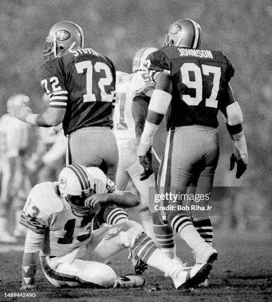 Miami Dolphins QB Dan Marino under heavy pressure and gets sacked for a loss from San Franciscos Jeff Stover , Dwaine Board and Gary Johnson during...