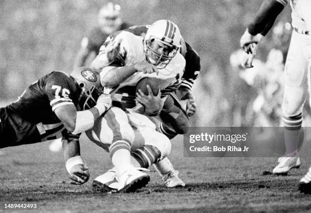 Miami Dolphins QB Dan Marino under heavy pressure and gets sacked for a loss from San Francisco Jeff Stover , Dwaine Board and Gary Johnson during...