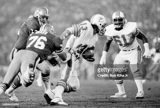 Miami Dolphins QB Dan Marino under heavy pressure and gets sacked for a loss from San Francisco Jeff Stover , Dwaine Board and Gary Johnson during...