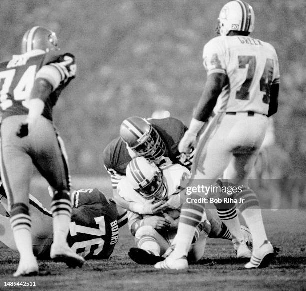 Miami Dolphins QB Dan Marino under heavy pressure and gets sacked for a loss from San Franciscos Jeff Stover , Dwaine Board and Gary Johnson during...