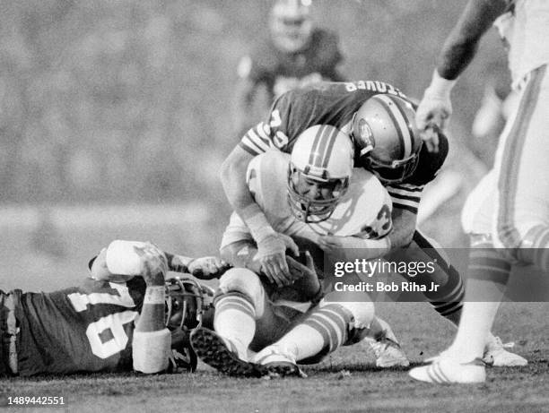 Miami Dolphins QB Dan Marino under heavy pressure and gets sacked for a loss from San Franciscos Jeff Stover , Dwaine Board and Gary Johnson during...