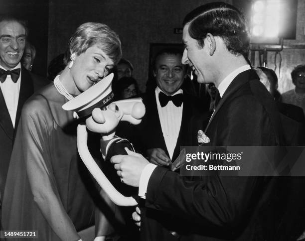 Prince Charles receives a presentation of a pink panther dressed in naval uniform from actress Julie Andrews , prior to the premiere of the film 'The...