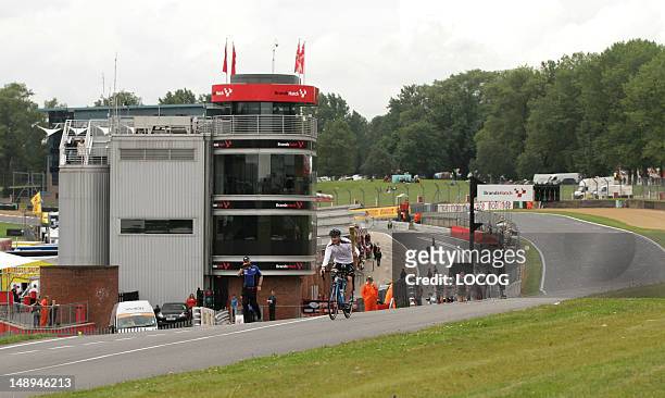 In this handout image provided by LOCOG, Torchbearer 056 Craig Preece rides the Olympic Flame around the race track of Brands Hatch on his mountain...