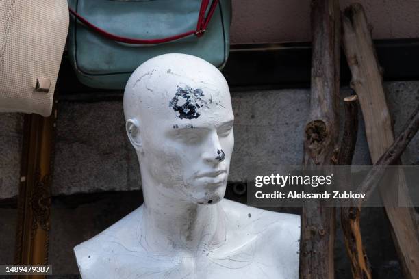 a broken and abandoned mannequin, in a faded condition. a dummy that is no longer in use. the face of a broken mannequin in the used clothing market area. an old worn-out mannequin with cracks and breakages. an old android, a cyborg. - broken mannequin stock pictures, royalty-free photos & images