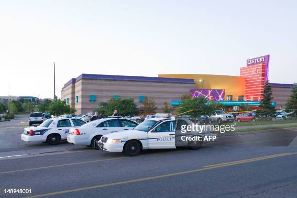 Police cars are seen in the parking area around the Century 16 movie theater in Aurora, Colorado, July 20, 2012 where a gunman opened fire during the...