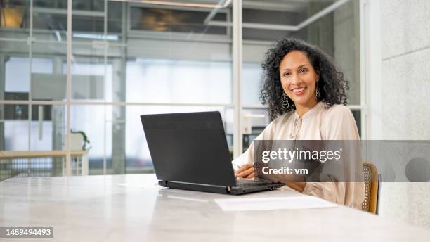 mujer de negocios usando computadora portátil en retrato de oficina - gestor de proyectos fotografías e imágenes de stock