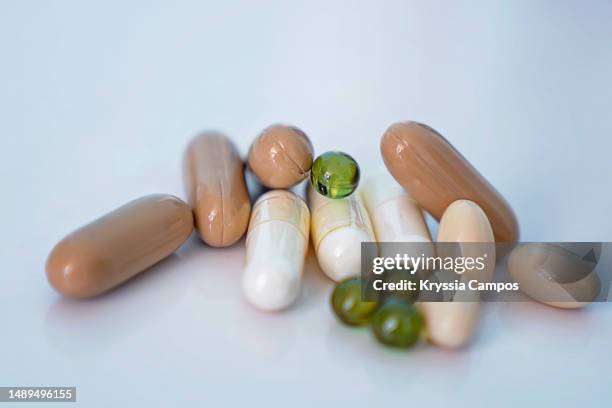 close-up of several different capsules over white background - vitamins and minerals stock pictures, royalty-free photos & images