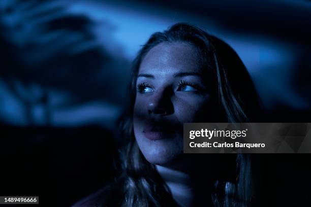 close up image of a lady looking away in darkroom. - darkroom fotografías e imágenes de stock