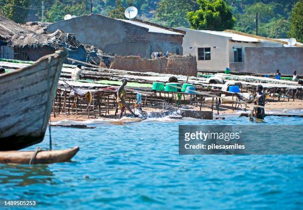 einheimische waschen kleidung an der küste, masaka-fischerdorf, malawisee, malawi, afrika. - see lake malawi stock-fotos und bilder