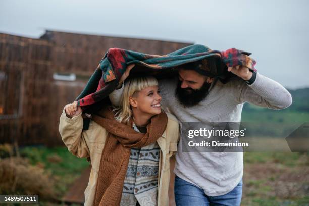 romantic couple outdoors in rain. - jacket stock pictures, royalty-free photos & images