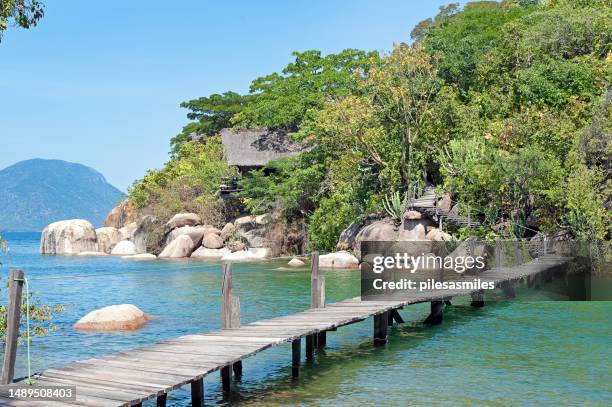 empty elevated walkway jetty between mumbo and jumbo islands, mumbo island, lake malawi, malawi, africa. - lake malawi stock pictures, royalty-free photos & images