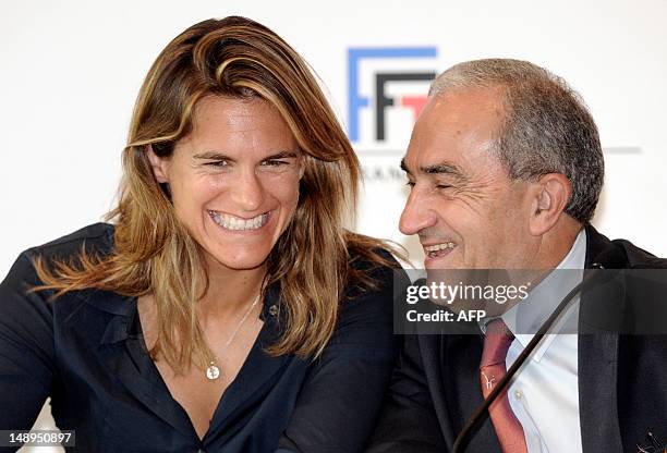 Former world number one Amelie Mauresmo smiles during a press conference next to the president of the French Tennis Federation , Jean Gachassin, on...