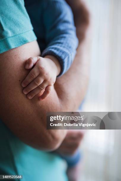 close up of a baby hand holding father's arm - fathers day stock pictures, royalty-free photos & images